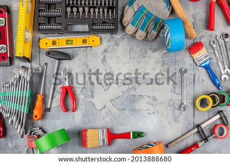 DIY and home improvement banner with work and construction tools on a wooden workbench top view, copy space at center. Instrumental hand tools background.