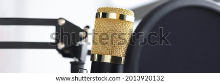 Closeup of golden microphone in recording studio