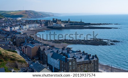 View across Aberystwyth on a hot July day looking across the curving Cardigan bay and blue seas. Wales, UK. Royalty-Free Stock Photo #2013937574