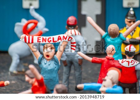 Closeup of tiny model England figurines celebrating football match