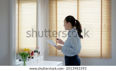 Young female leader, asia people lady or mba student happy standing smile look at in front of mirror pep talk for sale pitch hold paper document script public speak skill for job career self improve. Royalty-Free Stock Photo #2013983393
