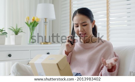 Upset mad asia people young girl consumer sit sofa at home open fake product order, damage post mail buy from online shopping retail store. Shock sad teen woman unbox from wrong bad shipping service. Royalty-Free Stock Photo #2013983402