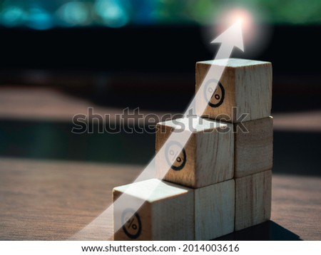 Shining rise up arrow on wooden blocks chart steps with percentage icons on wooden desk, business growth process, and economic improvement concept.