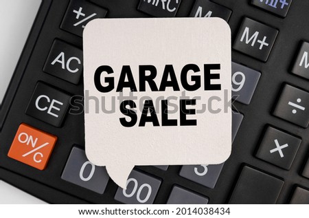 Business and economy concept. There is a white plate on the calculator with the inscription - GARAGE SALE
