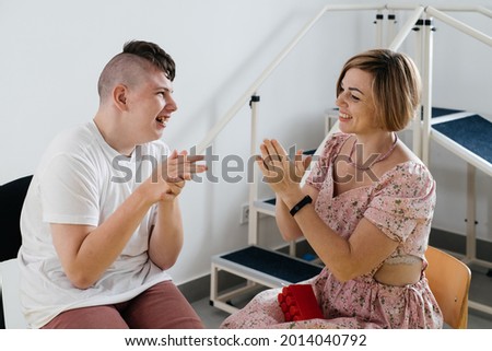 Therapist doing development activities with disabled teenage child. Boy with cerebral palsy having rehabilitation, learning, building. Mental training in medical care center  Royalty-Free Stock Photo #2014040792