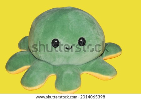 Green ash soft happy octopus on illumitating background. Happy toy. Emotion of happiness.