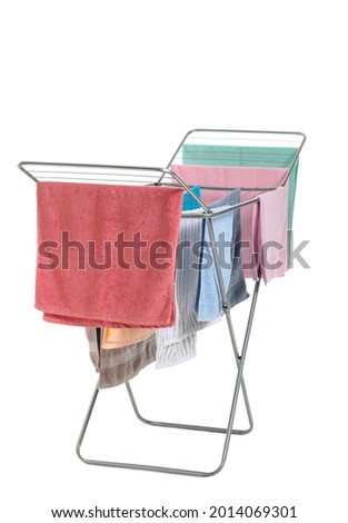 Clothes dryer with clean towels on white background