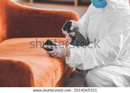 Worker in biohazard costume removing dirt from sofa in house Royalty-Free Stock Photo #2014069355