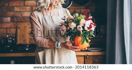Pumpkin with beautiful bouquet on hand. 