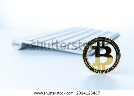 Bitcoin icon. Gold Crypto currency BTC Bitcoin with keyboard on white background. Golden Bit Coin virtual cryptocurrency or blockchain technology. Trading on the cryptocurrency exchange