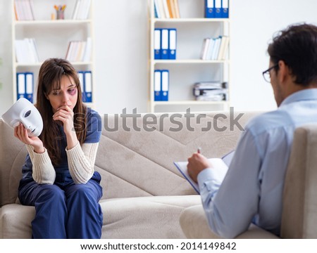 Woman suffering from home violence visiting doctor Royalty-Free Stock Photo #2014149842