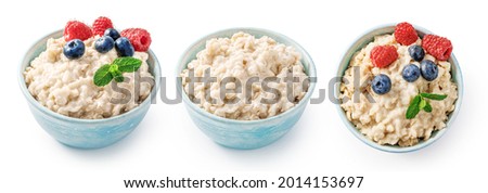Oatmeal porridge with blueberries and raspberries with fresh mint in blue bowl. Porridge isolated on white background. Set of bowls of porridge for package design. Royalty-Free Stock Photo #2014153697