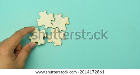 Top view of hand businessman  holding blank puzzle jigsaw pieces. Teamwork success and strategy concept, cooperation business solutions think or new idea, Security help support management, copy space.