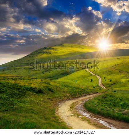 summer landscape. mountain path through the field turns uphill to the sky at sunset Royalty-Free Stock Photo #201417527