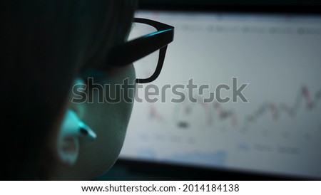 Businesswoman analyzing a graphic of a stock exchange chart. Woman hard working at home. Working late and overtime.