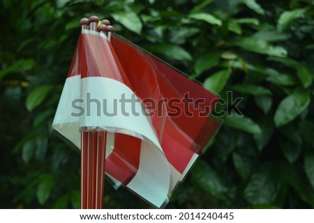 The National Flag of Indonesia, the Red and White Flag (bendera merah putih) made of plastic for use by children with blurry background