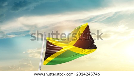 Jamaica national flag waving in beautiful clouds.