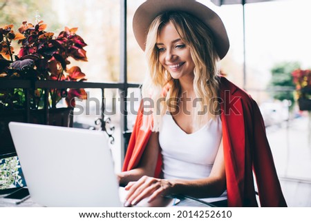 Happy Caucaisan hipster girl watching positive video vlog on modern laptop computer using 4g connection on leisure, joyful female blogger reading funny content publication browsed on netbook website