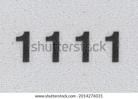 Black Number 1111 on the white wall. Spray paint. Number one thousand one hundred and eleven.