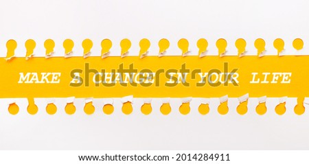 Torn paper strip on yellow background with text MAKE A CHANGE IN YOUR LIFE