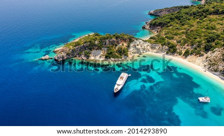 Aerial shot of moored luxury boats at the turquoise sea of Gidaki beach in Itaca, Greece