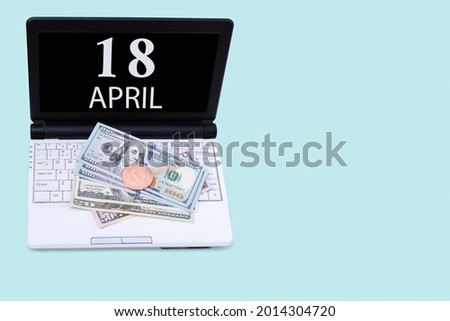 18th day of april. Laptop with the date of 18 april and cryptocurrency Bitcoin, dollars on a blue background. Buy or sell cryptocurrency. Stock market concept. Spring month, day of the year concept.