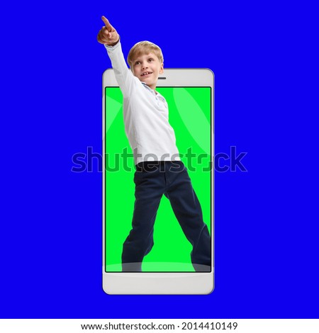 Happy schoolboy having online lesson in educational app on smartphone concept, blue chroma key on the background and green in the smart device