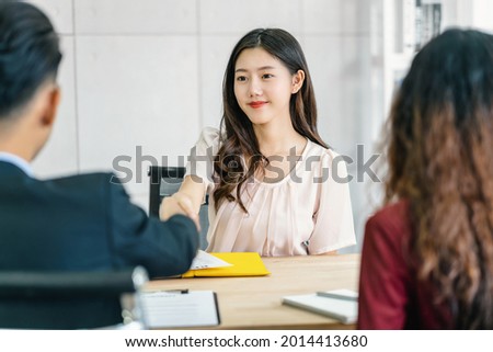 Young Asian woman graduate hand shake with two manager to welcome before start to job interview with positive motion in meeting room,Business Hiring new member,Job interview first impressions concept Royalty-Free Stock Photo #2014413680