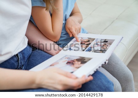 top view. mother and daughter watch photobook from discharge of newborn baby.family tradition of printing photos and looking at them with children and remembering.photographer and designer Royalty-Free Stock Photo #2014429178