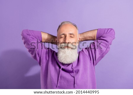 Portrait of attractive dreamy grey-haired man resting free time isolated over purple violet color background