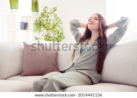 Profile side photo of young attractive girl happy positive smile hands behind head rest relax dream break sit sofa home