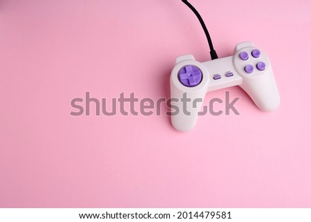 Video game joystick on pink background, closeup. Game addicted concept.