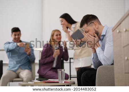 Coworkers bullying their colleague in office, space for text Royalty-Free Stock Photo #2014483052
