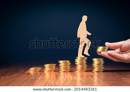 Return on investment, growing savings or wage income concept. Coins and wooden person going on increasing columns of coins. Helping hand adds more money. Successful investment concept. Royalty-Free Stock Photo #2014483361