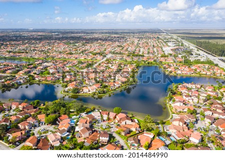 Luxury neighborhood with a large lake, trees and a blue sky in Miami.