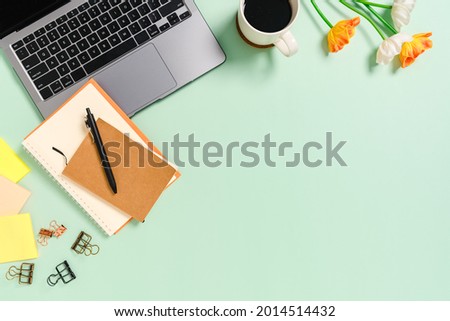Minimal work space - Creative flat lay photo of workspace desk. Top view office desk with laptop, coffee cup and notebook on pastel green color background. Top view with copy space photography.