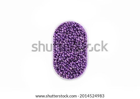 Plastic box with purple round beads isolated on white background. Top view. Copy space. Royalty-Free Stock Photo #2014524983