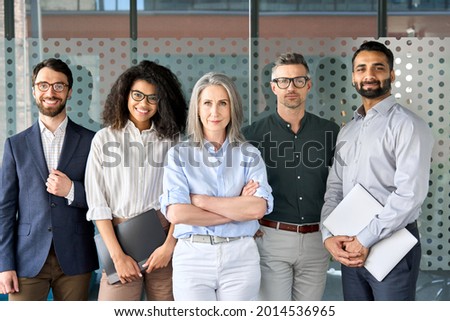 Happy diverse business people team standing together in office, group portrait. Smiling multiethnic international young professional employees company staff with older executive leader look at camera. Royalty-Free Stock Photo #2014536965