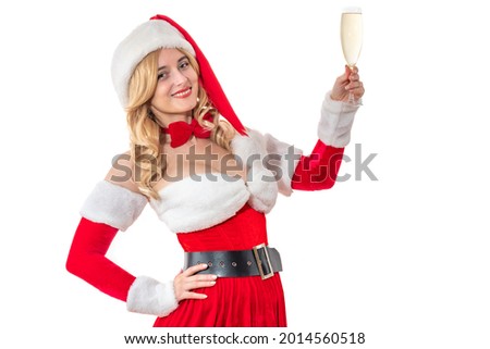 Lady Mrs. Santa Claus smiling happily holding a glass of champagne. Pretty woman in red dress. Cheerful pin-up girl in Santa’s hat. Female look at Christmas party, New Year festive carnival
