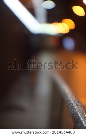 Metal railing in the foreground background blurred lights of lanterns of different colors