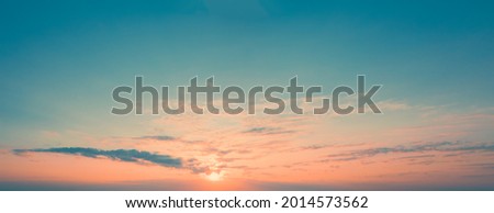 Panoramic picture of dawn sky with sun above the horizon surrounded by little cloudiness. Light Clouds at dawn. Orange Stripe of sky on blue horizon with rising sun, template for replacing sky.