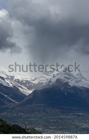 A vertical shot of snowy mountains under the dark sky