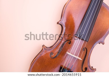A top view of violin isolated on light pink background