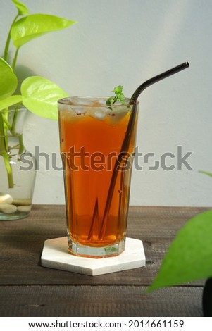 selective focus of a glass of iced tea on the wooden table