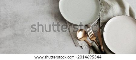 Plates mockup.Modern minimal table place setting neutral beige color on gray concrete background top view.Banner.  Space for text .  Modern kitchen.Scandinavian style tableware.