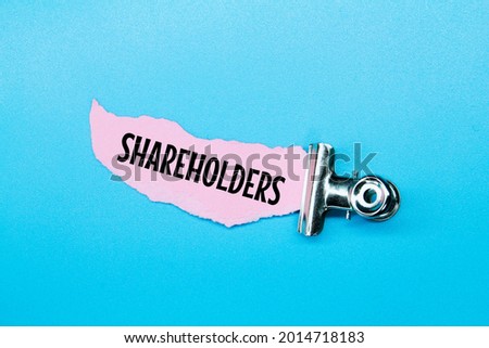 iron clamps, torn paper with the word SHAREHOLDER