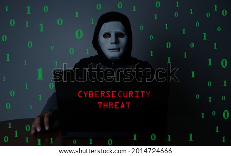 A low exposure and noise effect added picture of hacker with laptop insight, binary code and cybersecurity threat word. Hacking and cyber security threat concept.