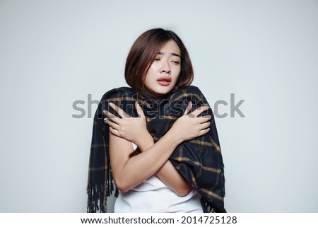 sick woman's body shivering in the cold using a dark scarf                                                             