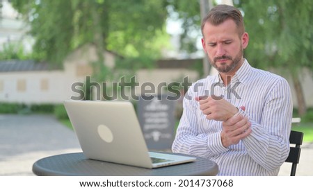 Mature Adult Man with Laptop having Wrist Pain 