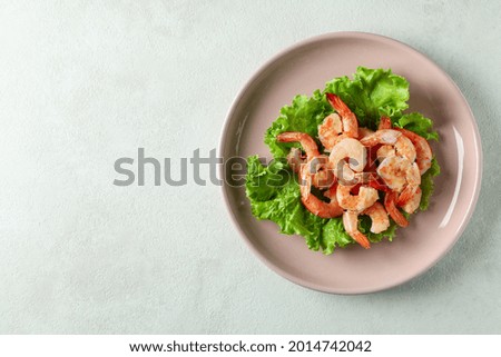 Plate of grilled shrimps on white textured table